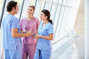 medical staff talking in hospital corridor with digital tablet