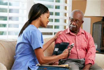 caregiver checking the health of a senior man