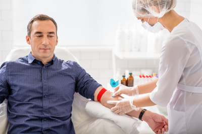 Skillful nurse is doing blood test for man in clinic